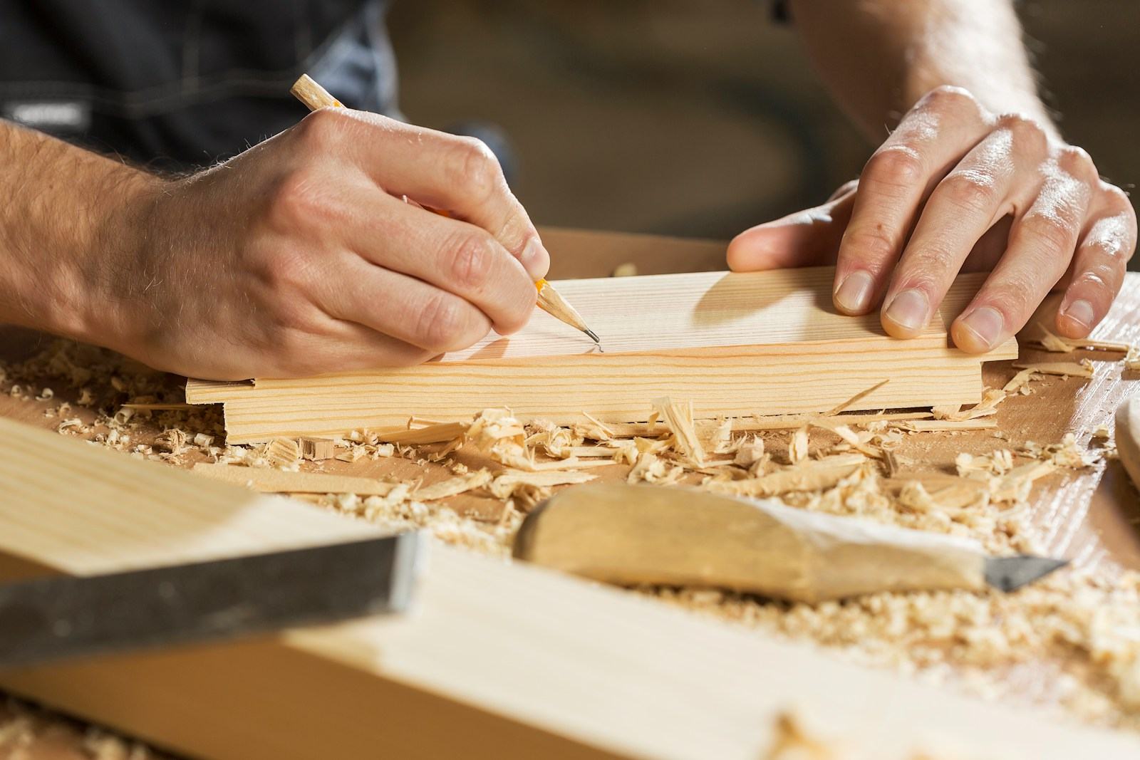Craftsman marking a piece of wood by hand in the workshop