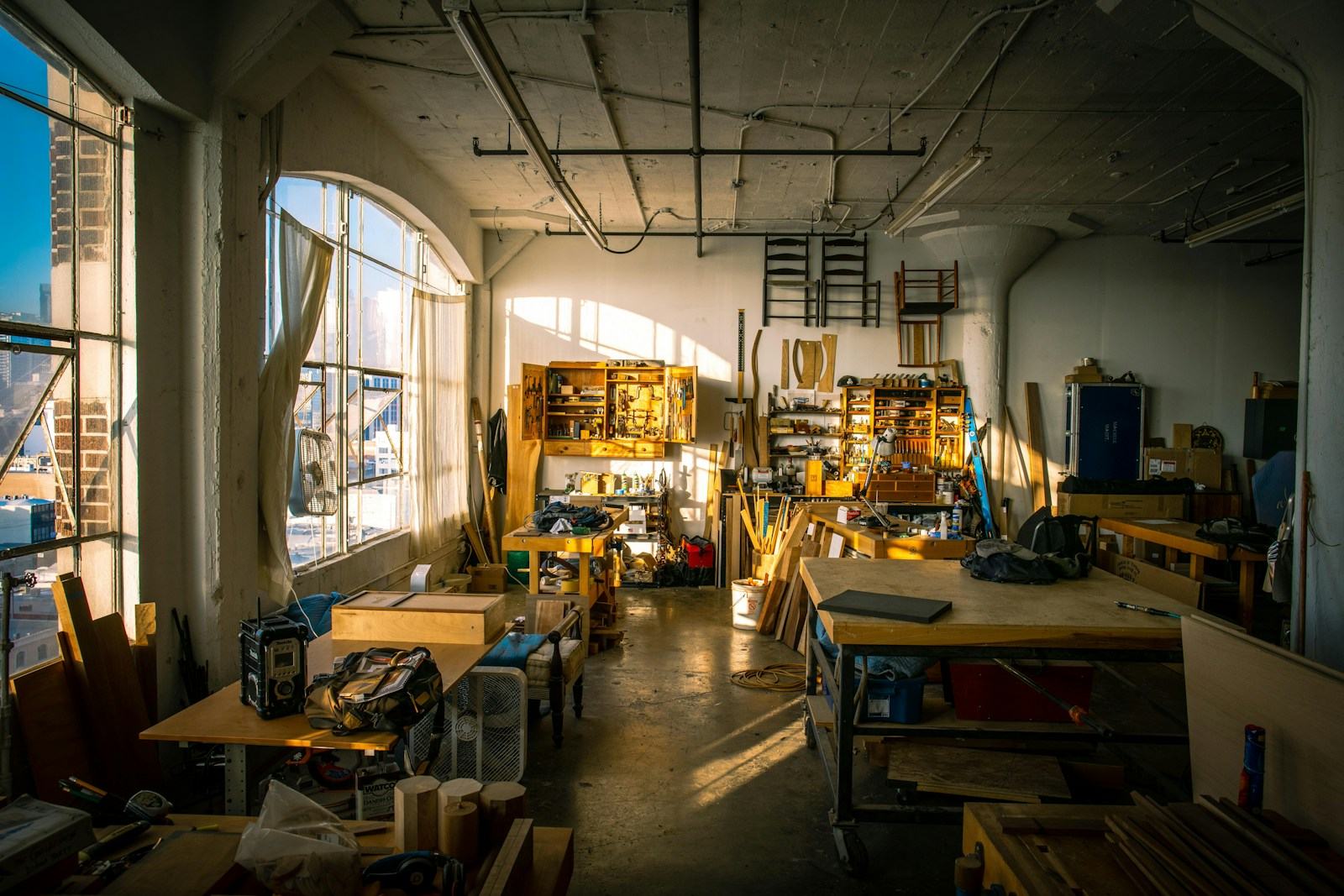 Sunlit furniture restoration workshop full of tools and wood